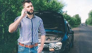 man with broken down car calling for emergency recovery